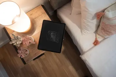 a book on a night stand next to a bed at Skyline Spa Athens 210 in Athens