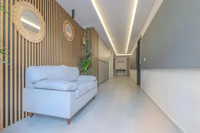 a living room with a white couch and a mirror at Port of Crete Apartment in Piraeus