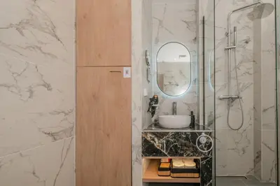 a bathroom with a sink and a mirror at Port of Crete Apartment in Piraeus