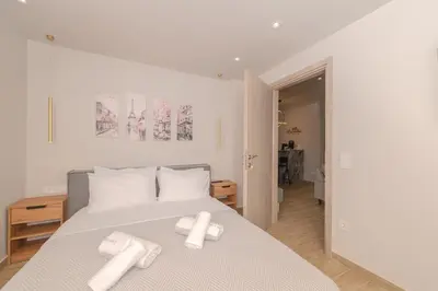 a bedroom with a bed with two towels on it at Dear Paris Apartment in Piraeus