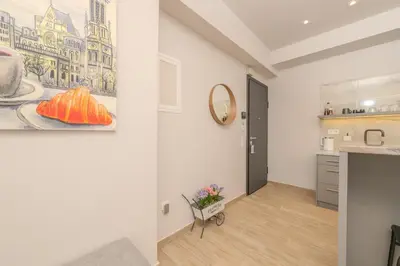 a living room with a painting on the wall and a table at Dear Paris Apartment in Piraeus