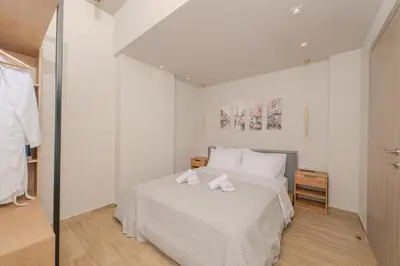 a bedroom with a white bed with two towels on it at Dear Paris Apartment in Piraeus