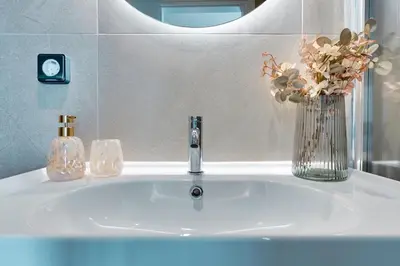 a bathroom sink with a vase of flowers and a mirror at Skyline Spa Athens 420 - 2bd in Athens