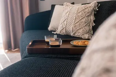 a tray with two glasses and a plate of food on a couch at Skyline Spa Athens 420 - 2bd in Athens