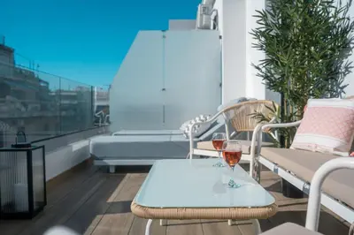 a table with a glass of wine on a balcony at Skyline Spa Athens 420 - 2bd in Athens