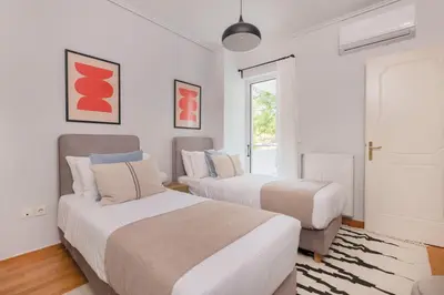 two beds in a room with white walls at Family Escape in Chalandri by UPSTREET in Athens
