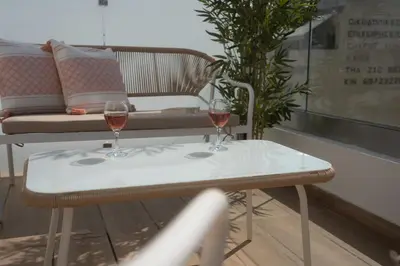 two glasses of wine on a table with a couch at Skyline Spa Athens 410 - 2bd in Athens