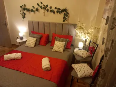 a bedroom with a large bed with red pillows at Luminous Apartment in Mesochórion