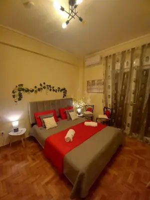 a bedroom with a large bed with a red blanket at Luminous Apartment in Mesochórion