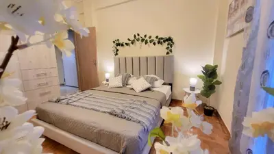 a bedroom with a bed with white flowers in it at Luminous Apartment in Mesochórion