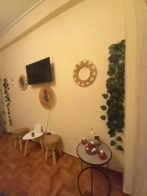 a living room with two tables and a flat screen tv at Luminous Apartment in Mesochórion