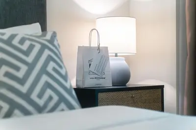 a bed with a lamp and a bag on a night stand at Skyline Spa Athens 020 in Athens