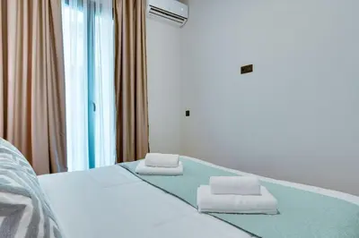 a bedroom with a bed with two towels on it at Skyline Spa Athens 020 in Athens