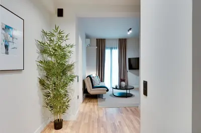 a living room with a couch and a chair and a plant at Skyline Spa Athens 020 in Athens