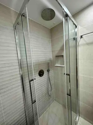 a shower with a glass door in a bathroom at Downtown modern apartment in Athens