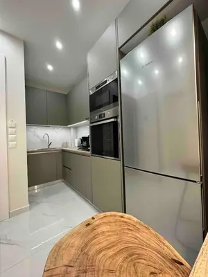 a kitchen with a wooden table and a refrigerator at Downtown modern apartment in Athens