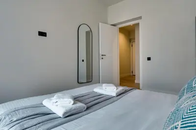 a white bedroom with a bed with towels on it at Skyline Spa Athens 310 in Athens