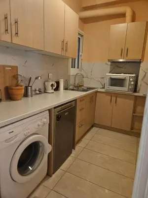 a kitchen with a washing machine and a microwave at Apartment in Athens in Athens