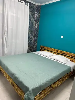 a bed in a room with a blue wall at Lilia Apartments in Athens