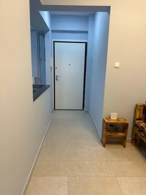 a hallway with blue walls and a door and a table at Lilia Apartments in Athens