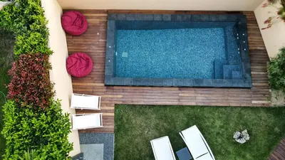 an overhead view of a swimming pool with chairs and plants at Lida Garden Loft in Anavissos
