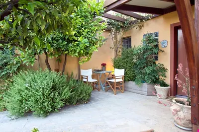 a patio with a table and chairs and plants at Lida Garden Loft in Anavissos