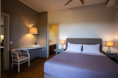 a bedroom with a bed and a desk and a chair at Lida Garden Loft in Anavissos