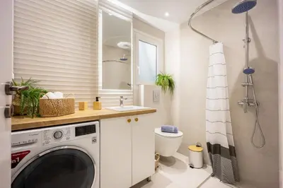 a bathroom with a washing machine and a sink at Sunny and friendly apartment in Piraeus