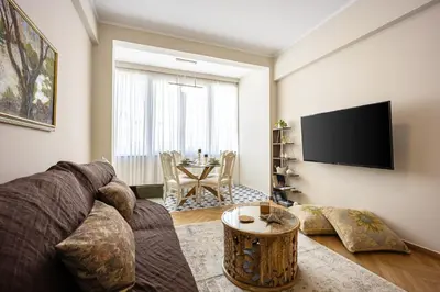 a living room with a couch and a flat screen tv at Sunny and friendly apartment in Piraeus