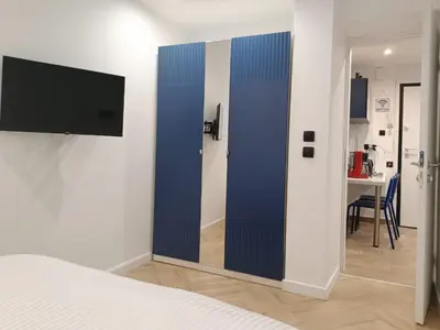 a room with a blue partition with a television on a wall at Blue Beach Apartment in Athens Alimos Kalamaki in Athens