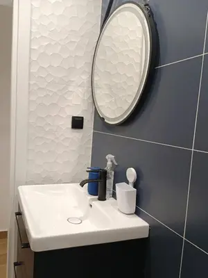 a bathroom with a white sink and a mirror at Blue Beach Apartment in Athens Alimos Kalamaki in Athens