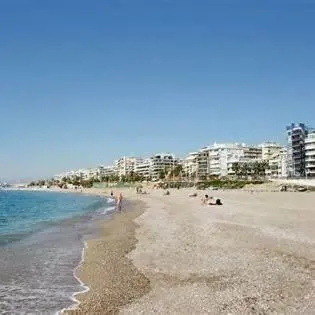 a beach with people and buildings in the background at Blue Beach Apartment in Athens Alimos Kalamaki in Athens