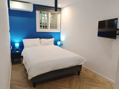 a bedroom with a bed with a blue wall at Blue Beach Apartment in Athens Alimos Kalamaki in Athens