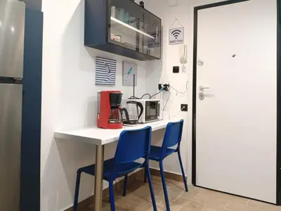 a kitchen with a table and two blue chairs at Blue Beach Apartment in Athens Alimos Kalamaki in Athens