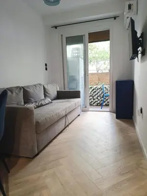 a living room with a couch and a sliding glass door at Blue Beach Apartment in Athens Alimos Kalamaki in Athens