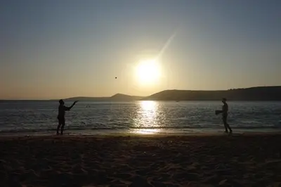 two people standing on the beach at sunset at Villa Dendron in Aghia Marina