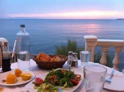 a table with a plate of food and a basket of food at Villa Dendron in Aghia Marina