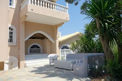 a house with a couch and a chair in front of it at Villa Dendron in Aghia Marina