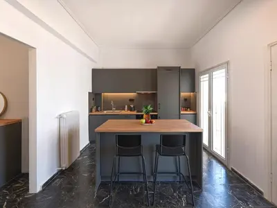 a kitchen with a island with two bar stools at Top-Floor Modern Penthouse with Stunning Sea Views in Piraeus