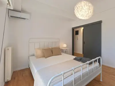a bedroom with a white bed and a chandelier at Top-Floor Modern Penthouse with Stunning Sea Views in Piraeus