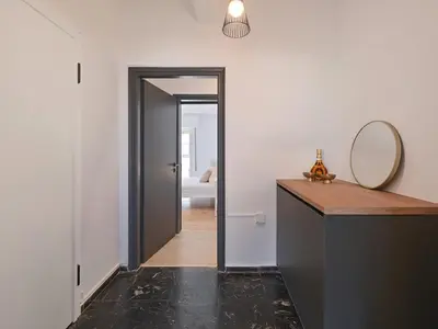 a hallway with a mirror and a door with a counter at Top-Floor Modern Penthouse with Stunning Sea Views in Piraeus