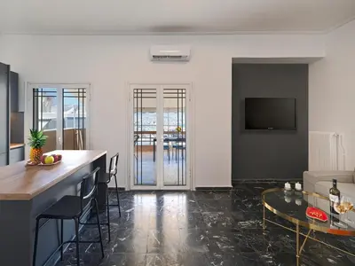 a living room with a bar and a table at Top-Floor Modern Penthouse with Stunning Sea Views in Piraeus
