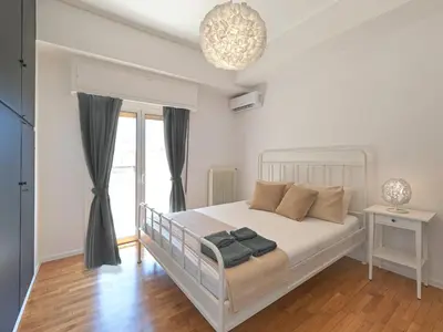 a white bedroom with a bed and a window at Top-Floor Modern Penthouse with Stunning Sea Views in Piraeus
