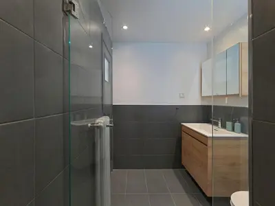 a bathroom with a glass shower and a sink at Top-Floor Modern Penthouse with Stunning Sea Views in Piraeus