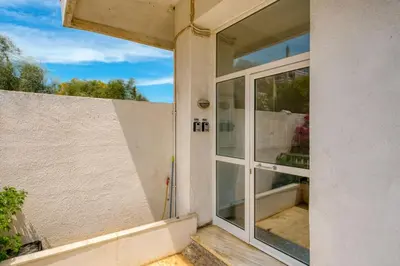 a sliding glass door on the side of a house at Royal Fig Apartment Porto Rafti in Porto Rafti
