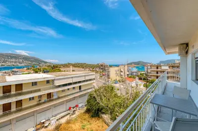 a balcony with a view of a city at Royal Fig Apartment Porto Rafti in Porto Rafti