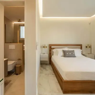 a white bedroom with a bed and a bathroom at Luxury Modern Apartment with Stunning Glyfada View in Athens