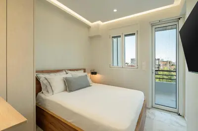 a bedroom with a bed and a large window at Luxury Modern Apartment with Stunning Glyfada View in Athens