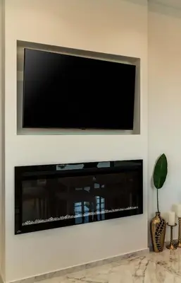 a flat screen tv on a wall with a fireplace at Luxury Modern Apartment with Stunning Glyfada View in Athens