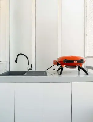 a kitchen with an orange pillow on a stove at Luxury Modern Apartment with Stunning Glyfada View in Athens